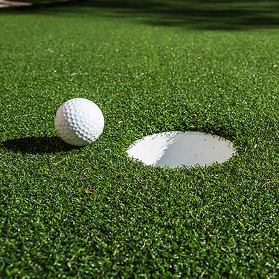 Close Up Of A Gold Ball On Synthetic Turf